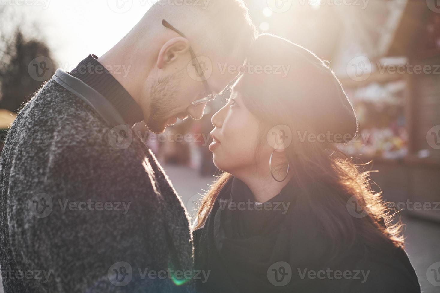 hermosa luz del sol. feliz pareja multirracial juntos al aire libre en la ciudad foto