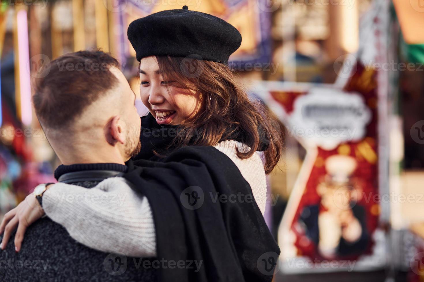 Happy multiracial couple together outdoors in the city. Asian girl with her caucasian boyfriend photo