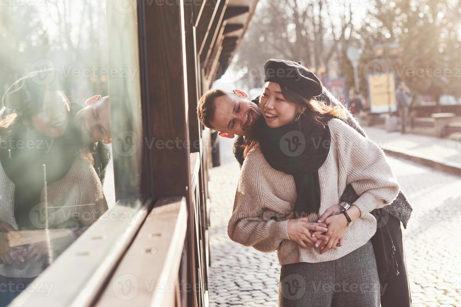 Playful and lovely multiracial couple together outdoors in the city. Asian girl with her caucasian boyfriend photo