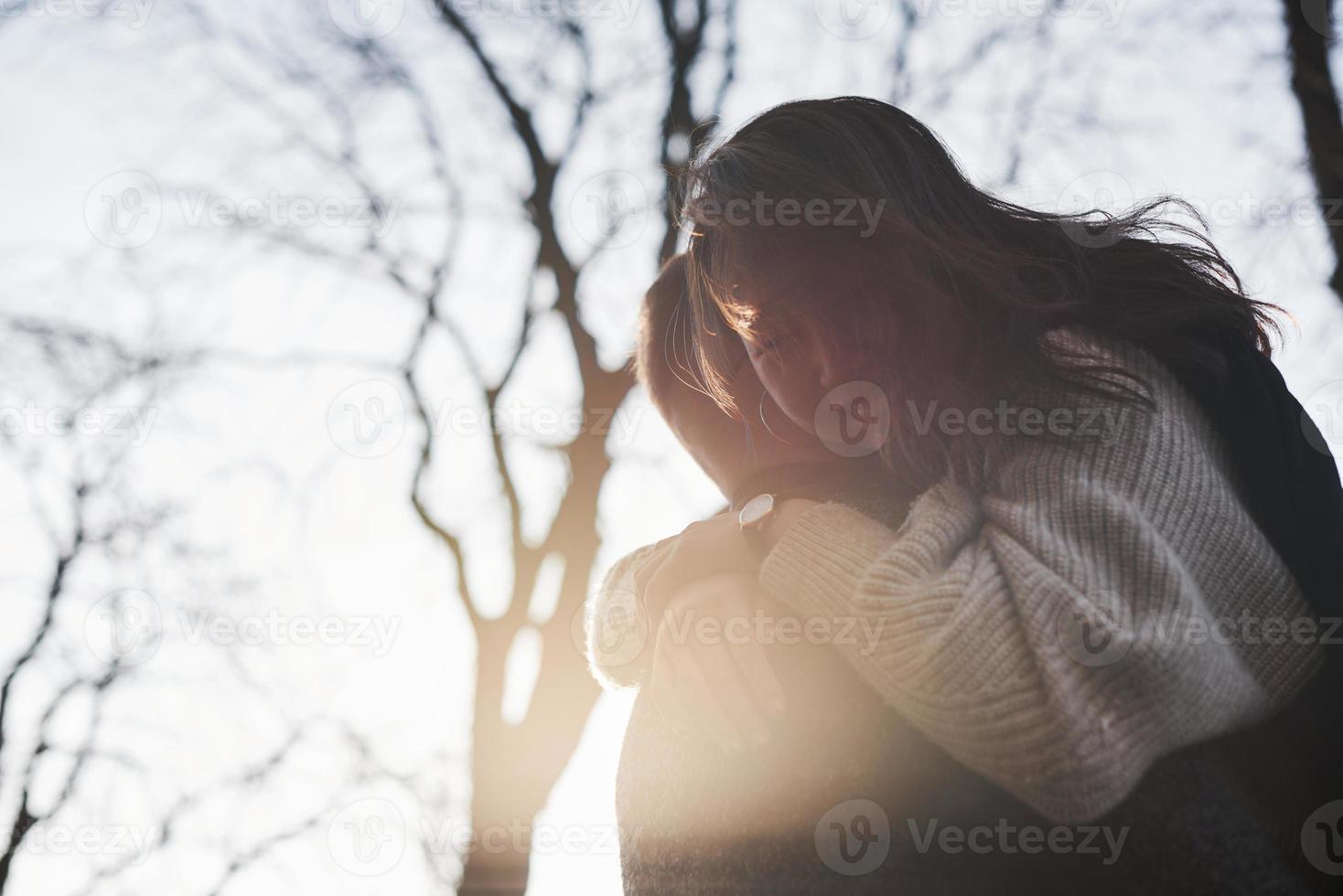 Cheerful multiracial couple embracing each other outdoors in the city. Asian girl with her caucasian boyfriend photo