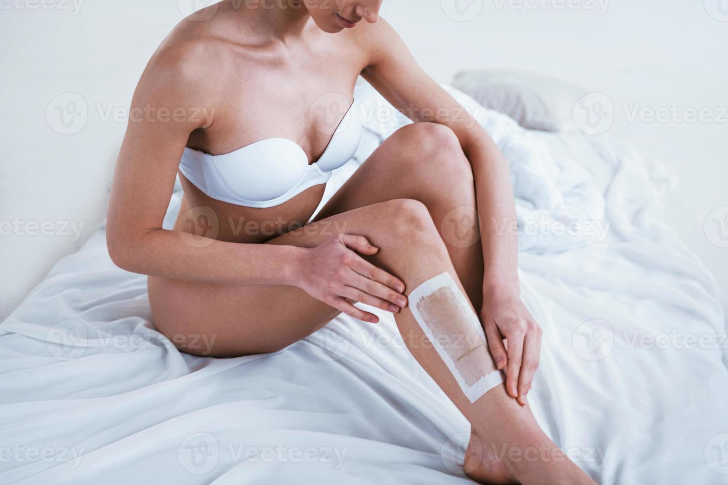 Young woman in underwear and with nice body shape with shaving gel in the studio against white background photo