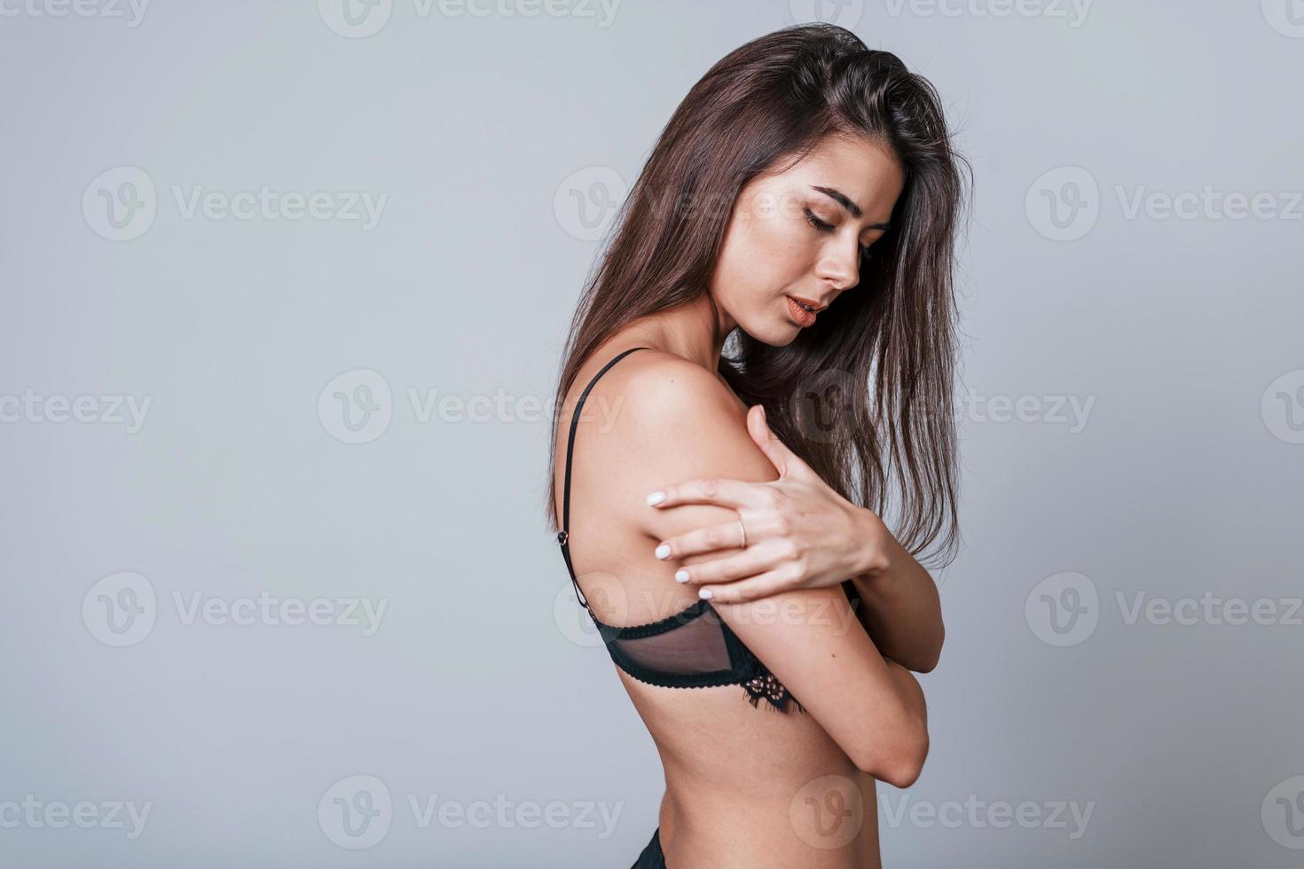 Sexy woman in black underwear standing in the studio against grey  background 15248984 Stock Photo at Vecteezy