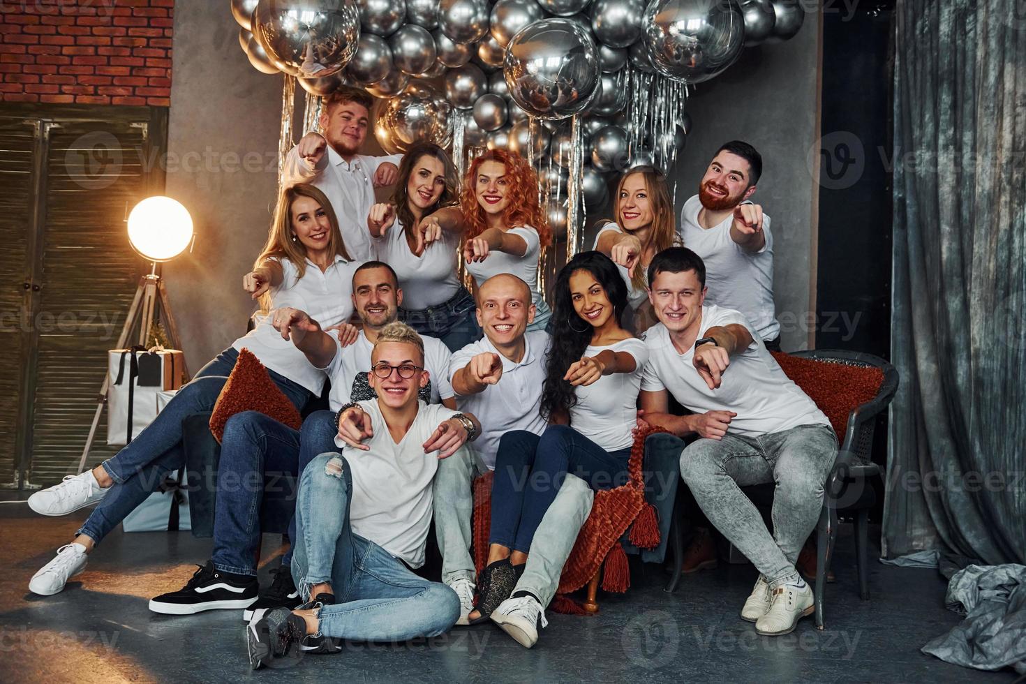 jóvenes felices celebrando el año nuevo en una habitación decorada con navidad con equipo de iluminación foto