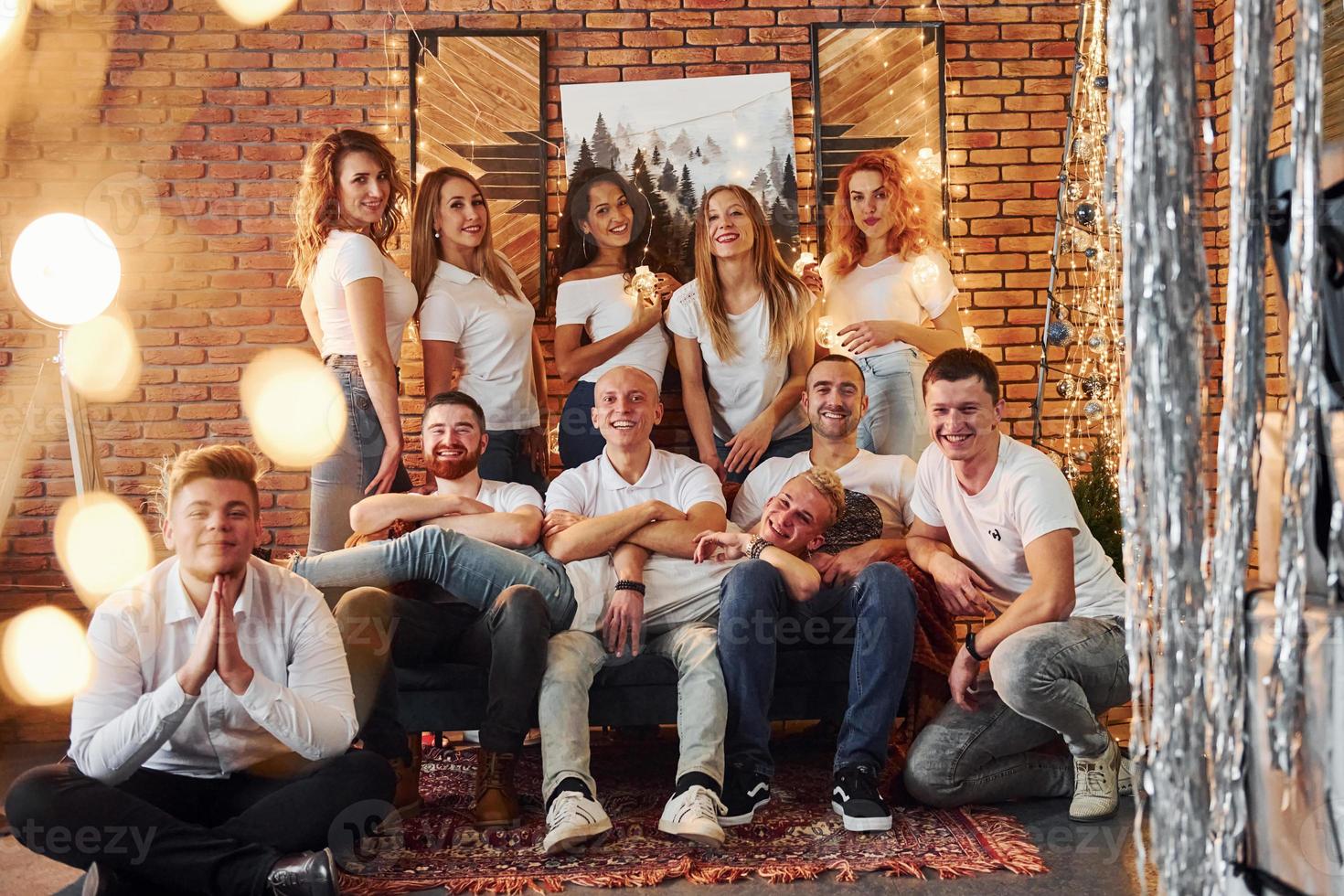 jóvenes sonrientes celebrando el año nuevo juntos en una acogedora habitación decorada con navidad foto