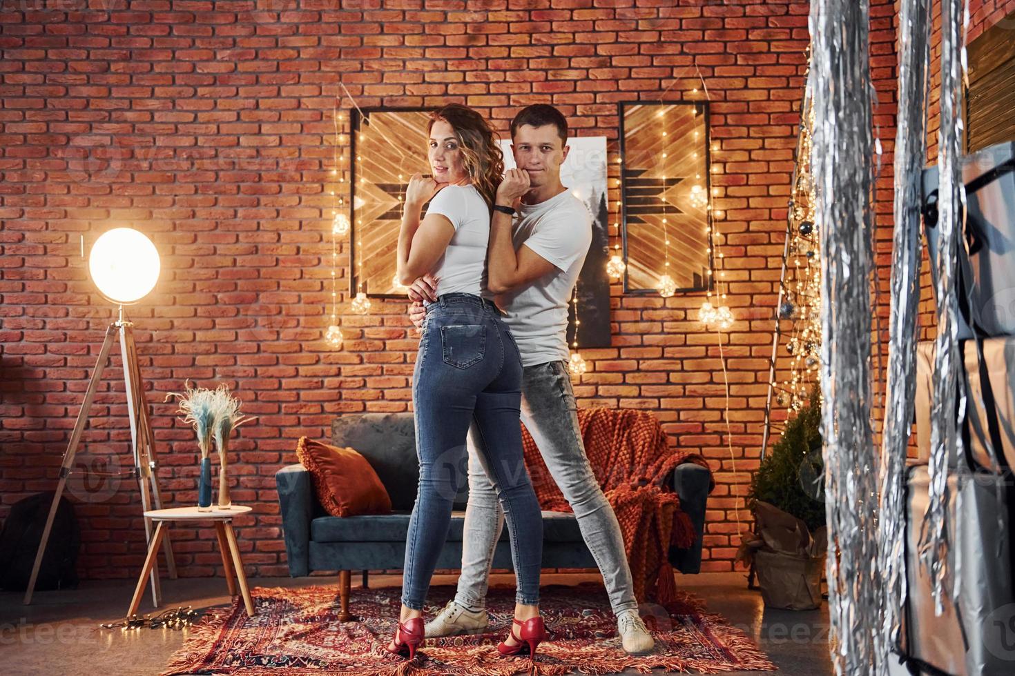 Couple standing in christmas decorated room together. Celebrating New Year photo