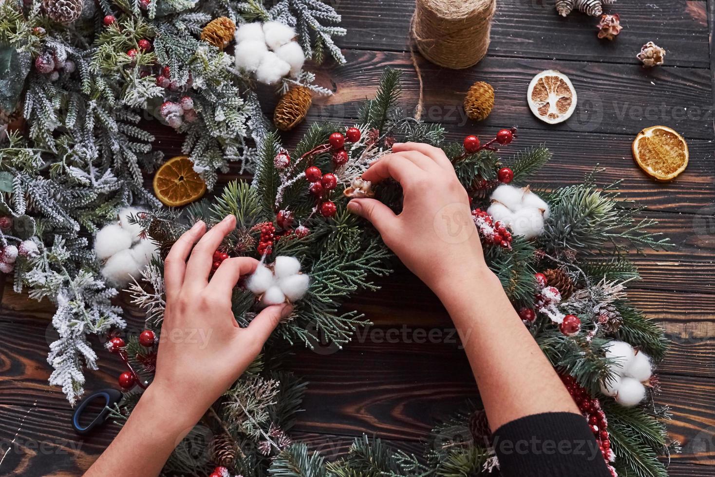 Hands taking care of ornament. Top view of christmas festive frame with new year decorations photo