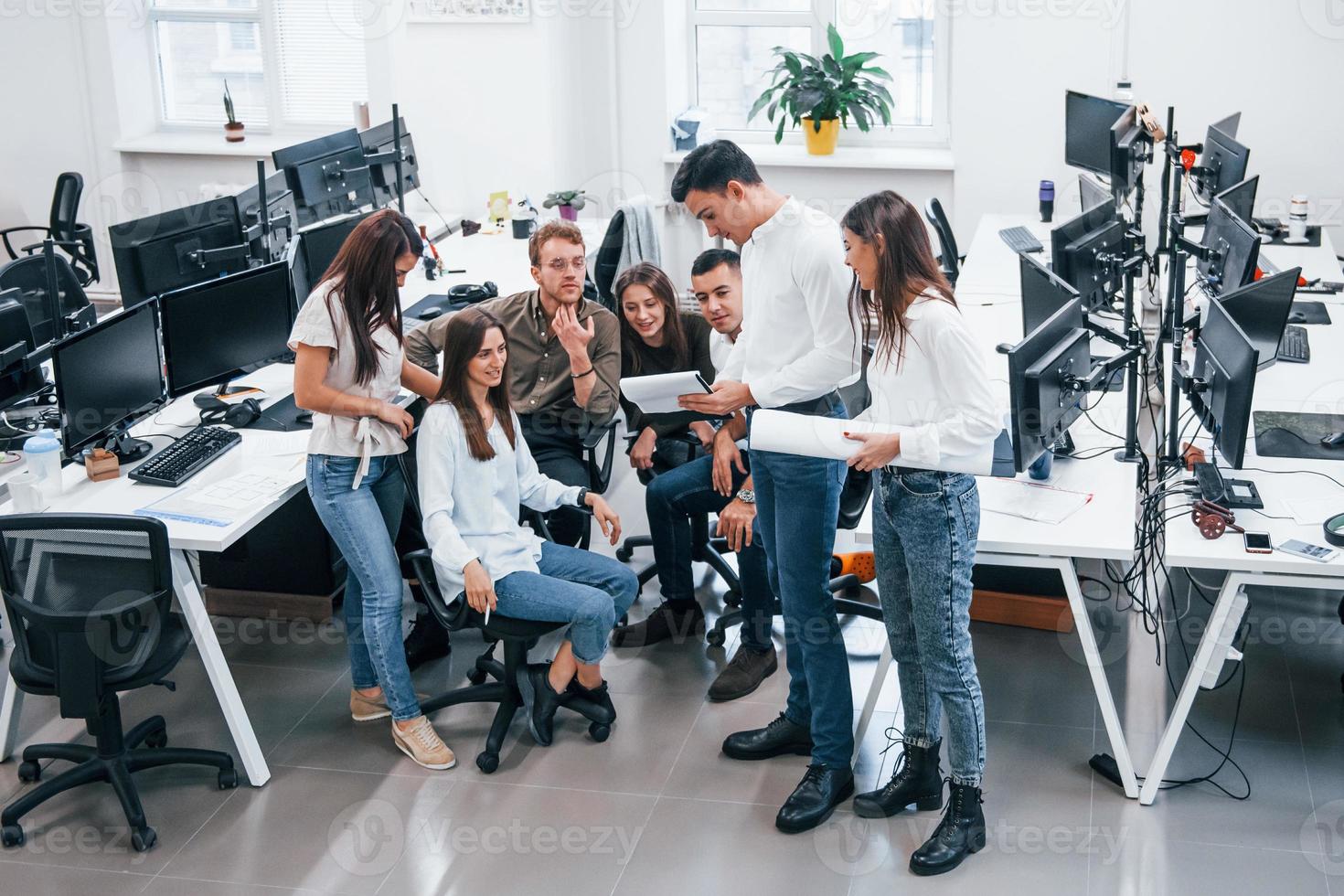 People talking and working together in the modern office near computers photo