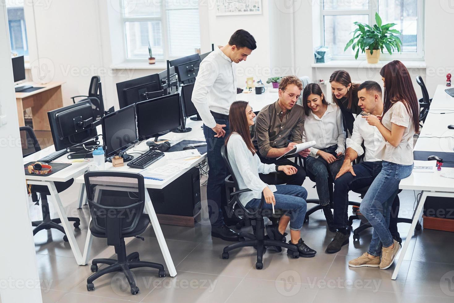 Group of young employees talking and working at new project in the office photo