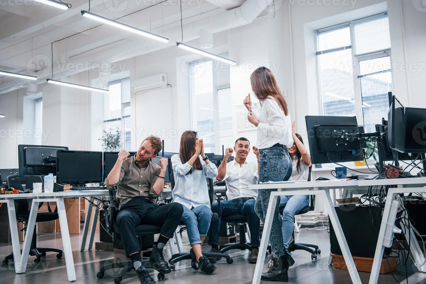 People talking and working together in the modern office near computers photo