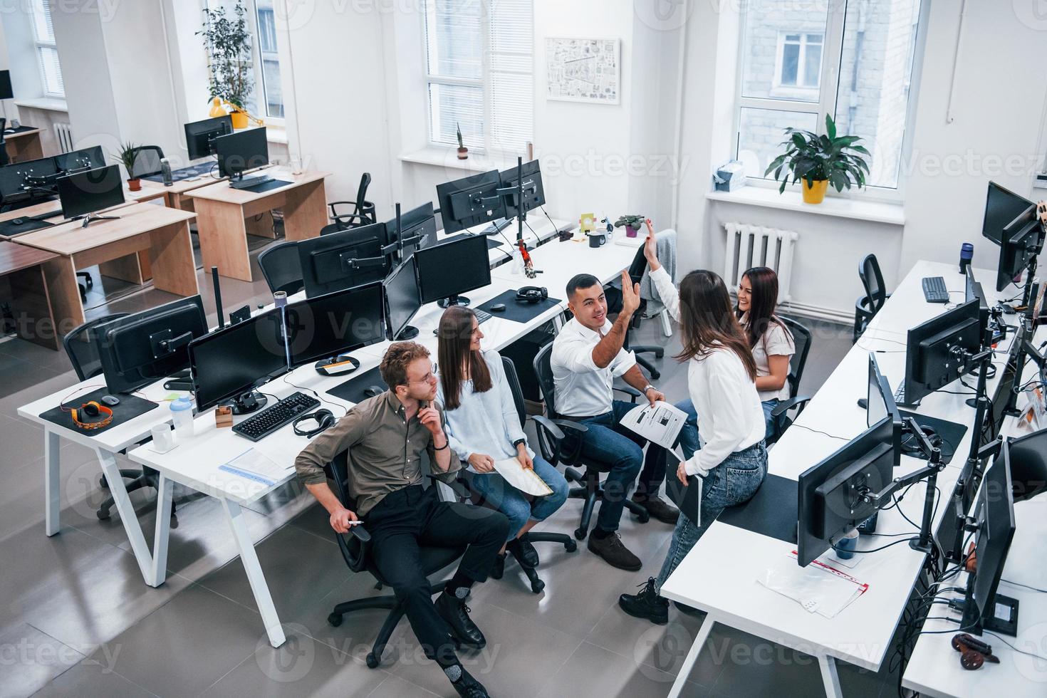 People talking and working together in the modern office near computers photo