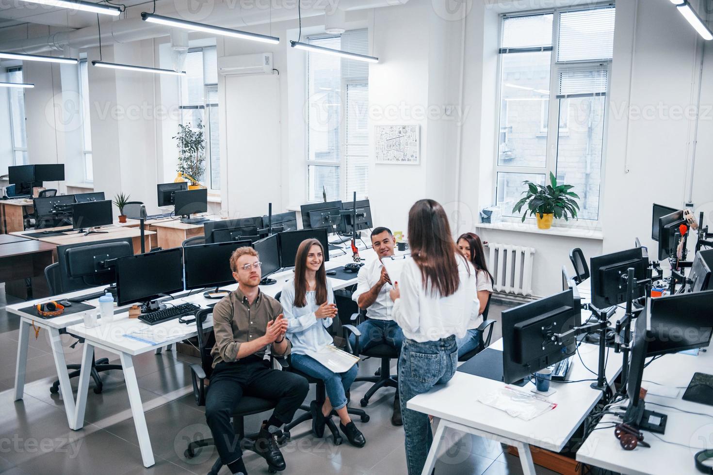 People talking and working together in the modern office near computers photo