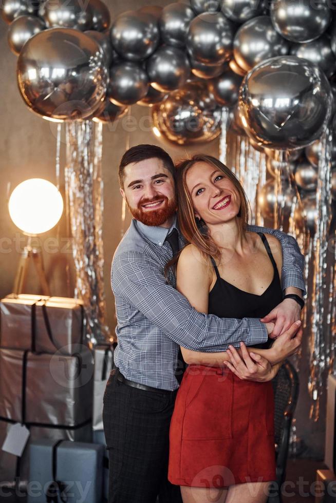 la pareja está en una habitación decorada con navidad juntos. celebrando el año nuevo foto