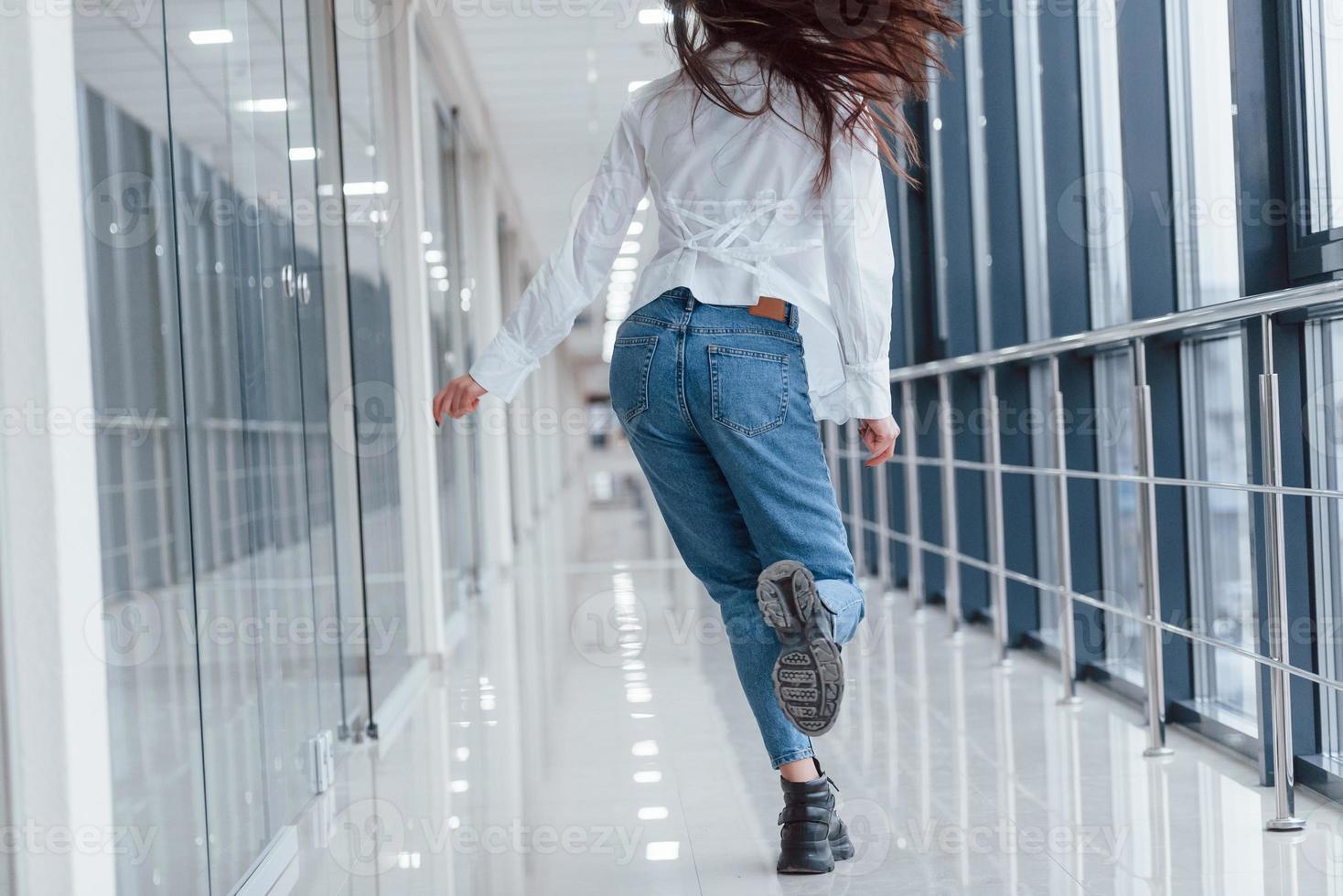 El principio altavoz moverse vista trasera de una chica con camisa blanca que camina adentro en un  aeropuerto moderno o en un pasillo durante el día 15250387 Foto de stock en  Vecteezy