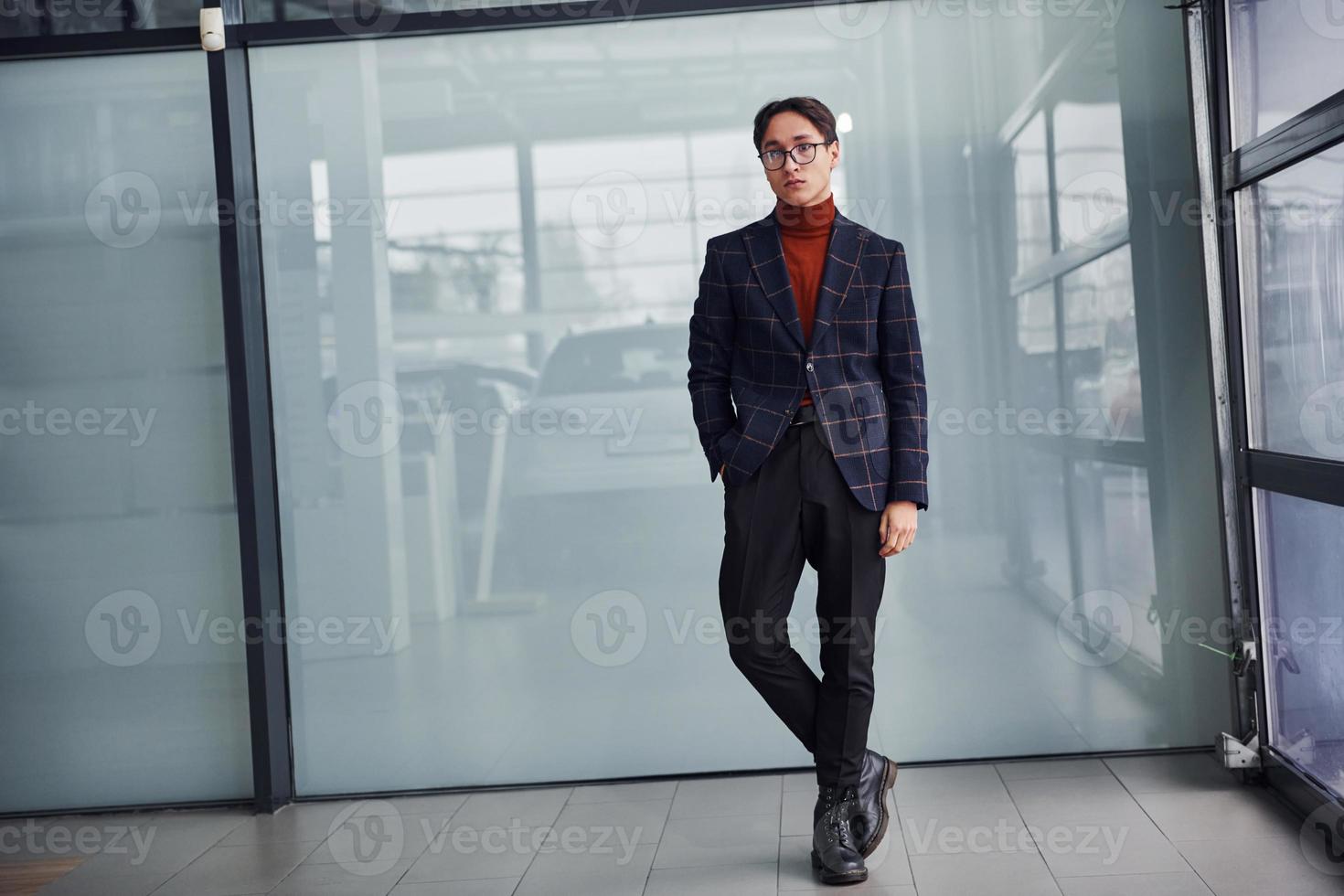 Young business man in luxury suit and formal clothes posing for the camera indoors photo