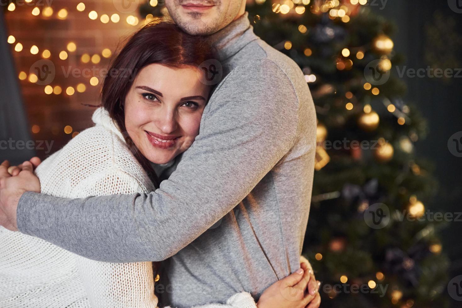 Couple embracing each other indoors in christmas decorated room photo