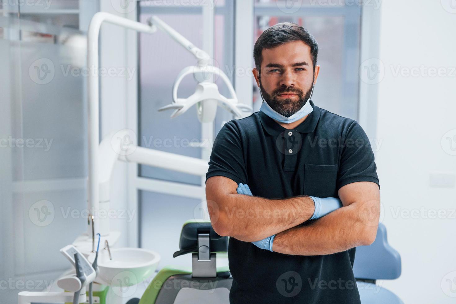 Portrait of dentist in gloves that standing indoors in the clinic photo