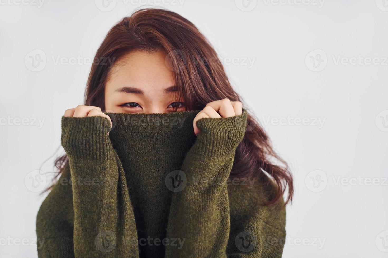 retrato de una joven asiática feliz que está de pie en el interior del estudio con fondo blanco foto