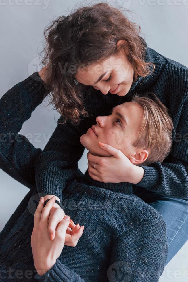 Cute young couple embracing each other indoors in the studio photo
