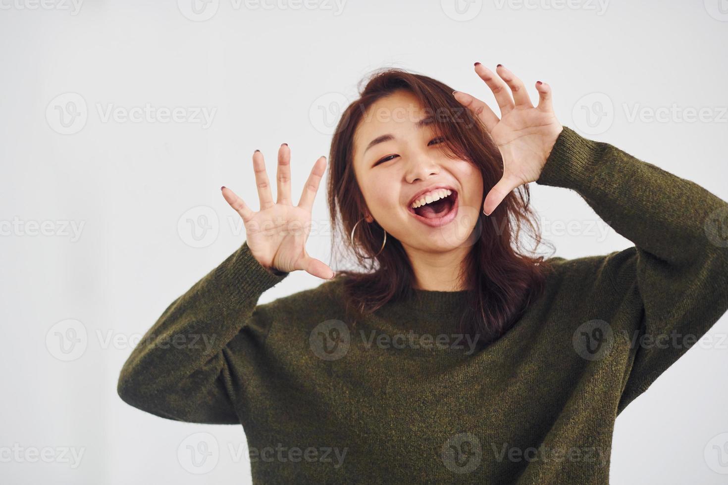 Portrait of happy asian young girl that standing indoors in the studio against white background photo