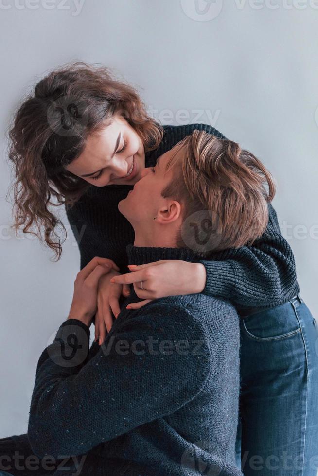 Cute young couple embracing each other indoors in the studio photo