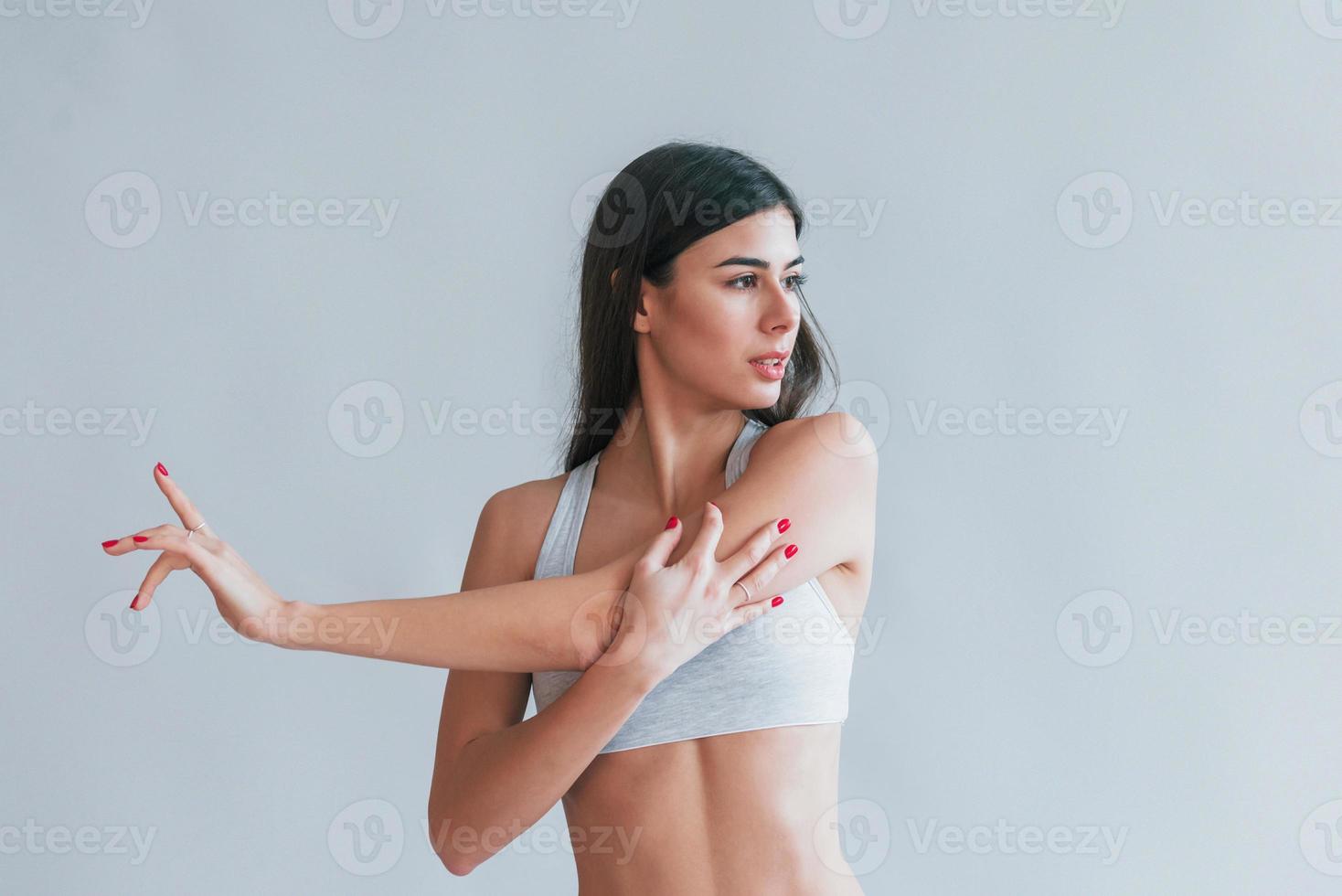 Young beautiful brunette in underwear is indoors in the studio