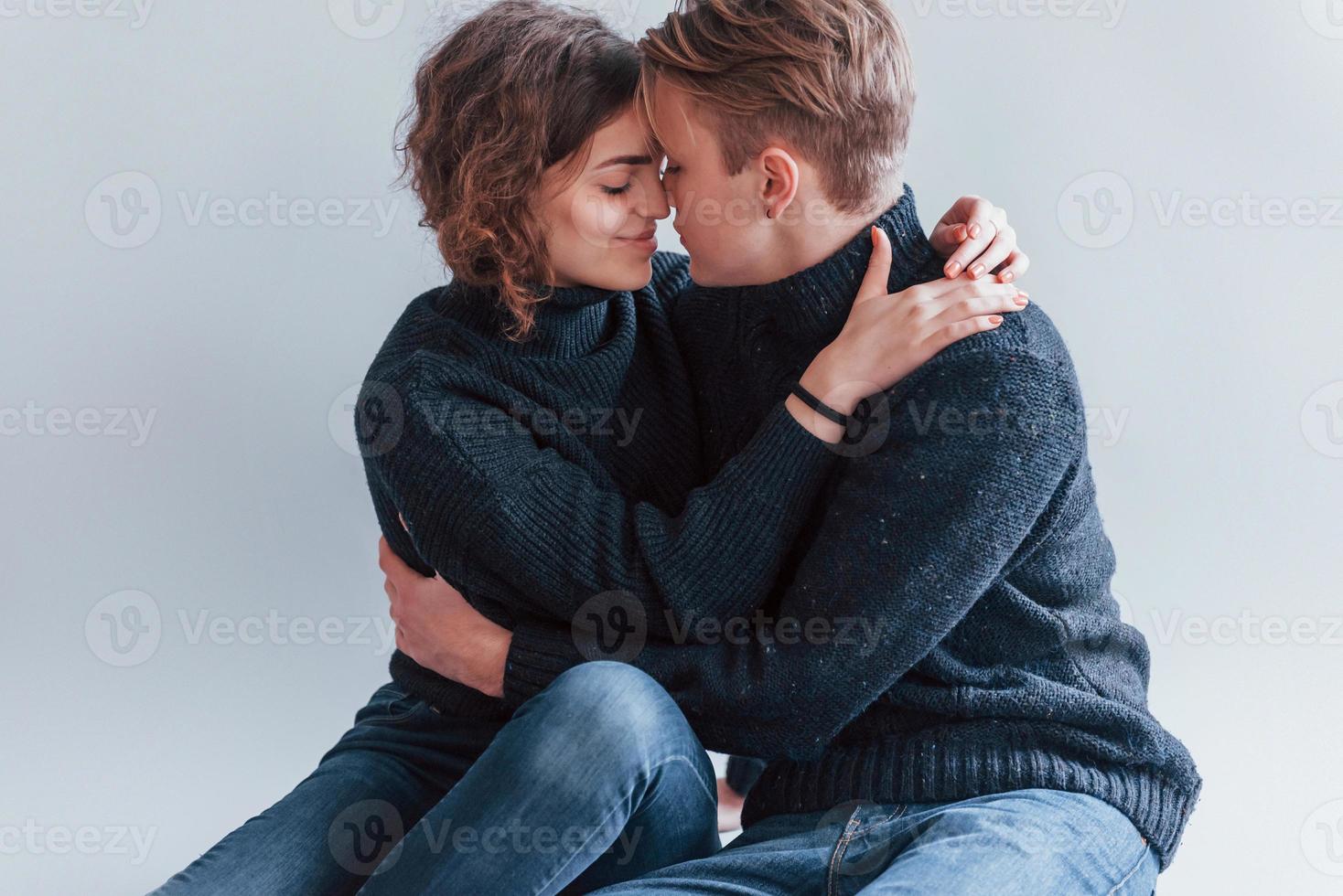 Cute young couple embracing each other indoors in the studio photo