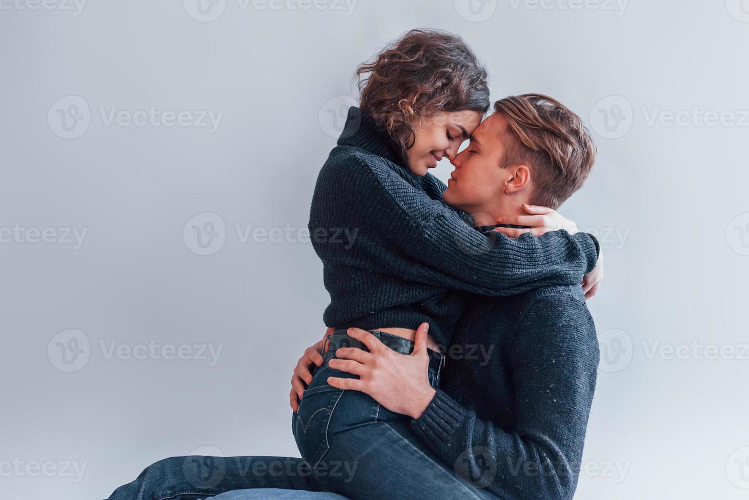 Cute young couple embracing each other indoors in the studio photo