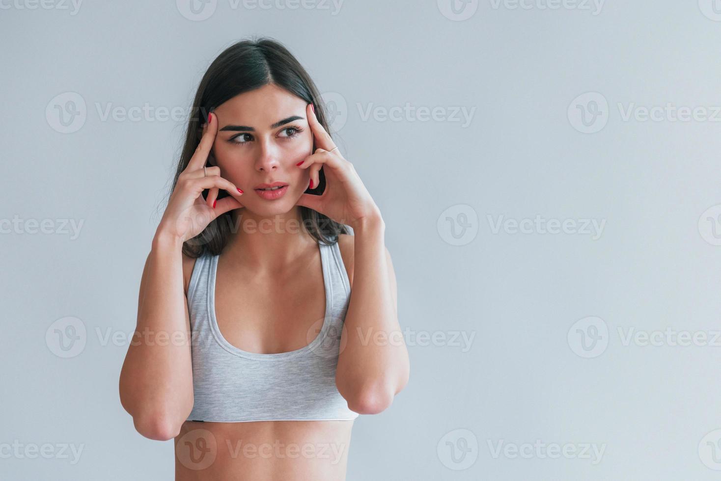 Young beautiful brunette in underwear is indoors in the studio