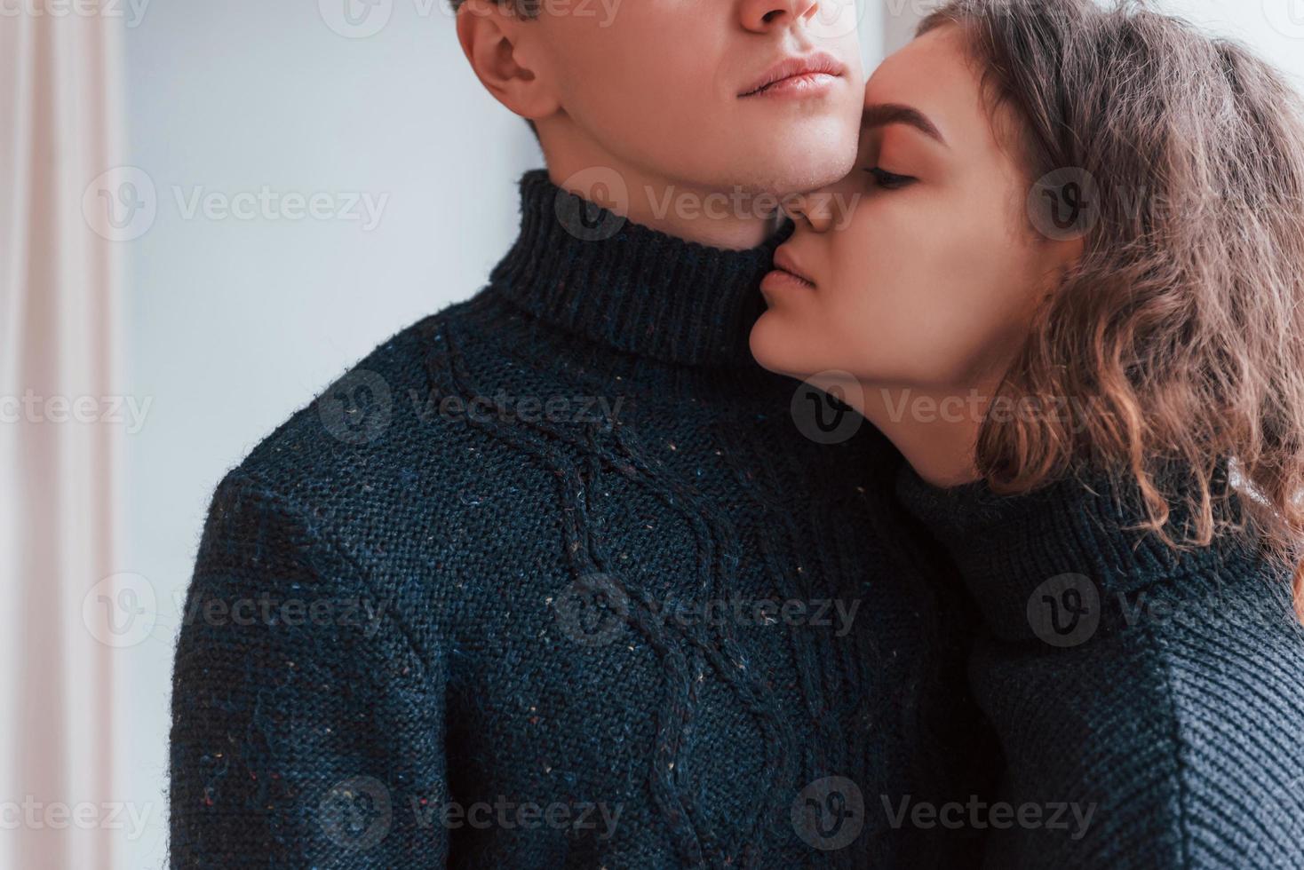 Cute young couple embracing each other indoors in the studio photo
