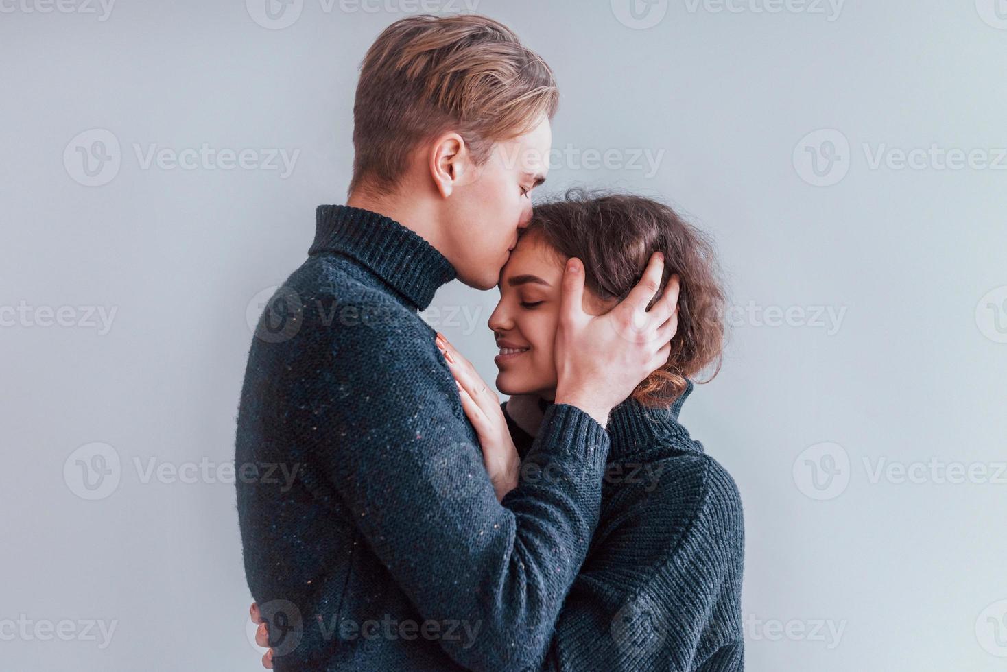 linda pareja joven abrazándose unos a otros en el interior del estudio foto