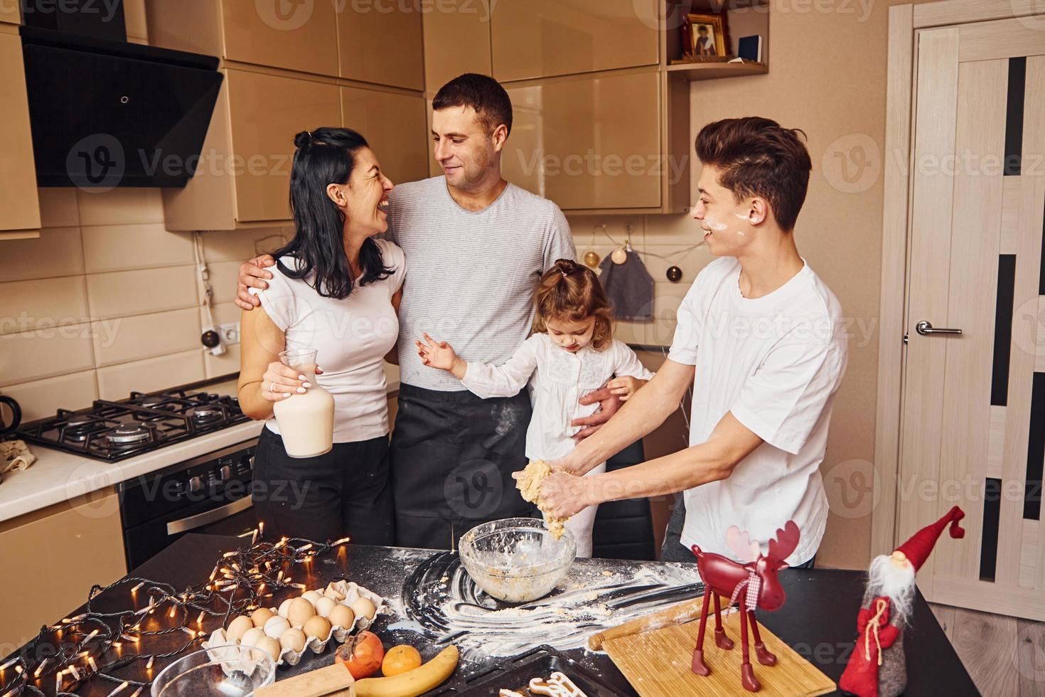 Happy family have fun on the kitchen and preparing food photo