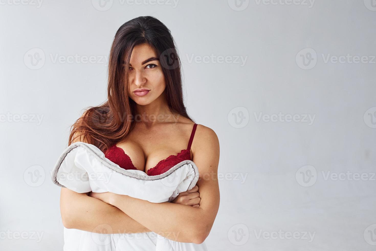 Woman in red underwear covering her body by towel in the studio against white background photo