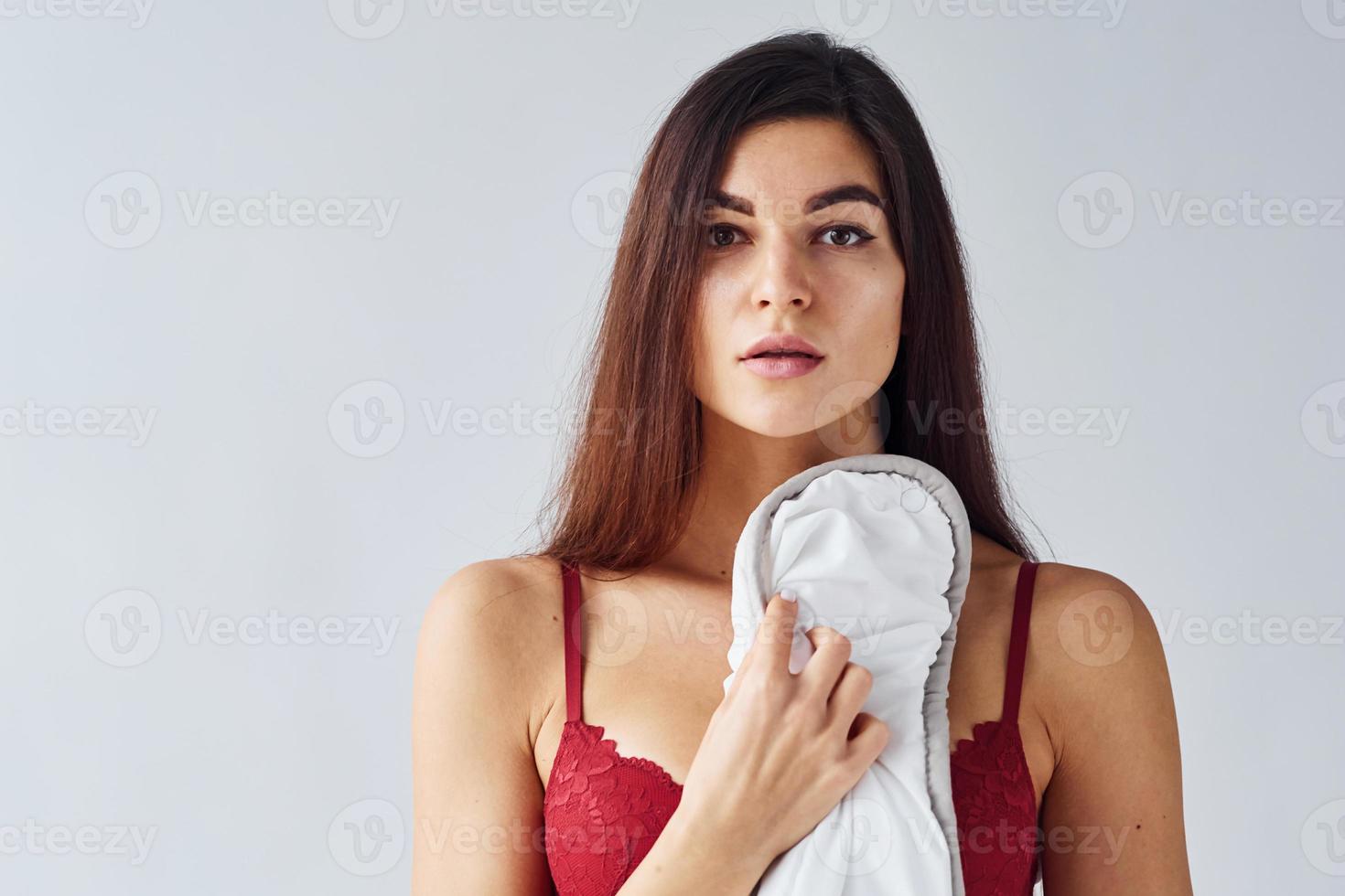 Woman covering her body by towel in the studio against white background photo