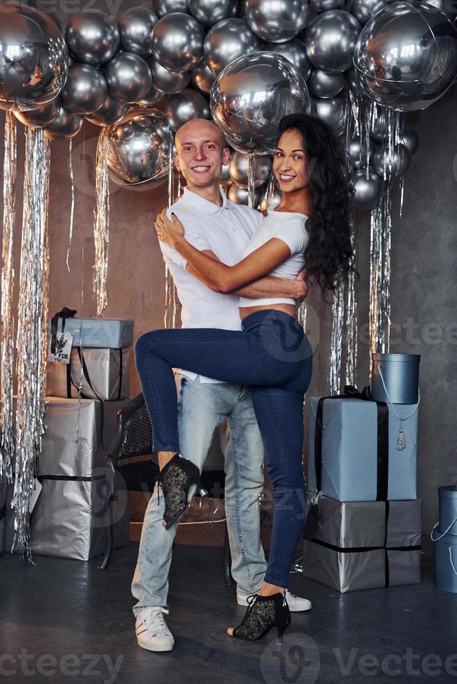 Couple is in christmas decorated room have fun and dancing. Celebrating New Year photo
