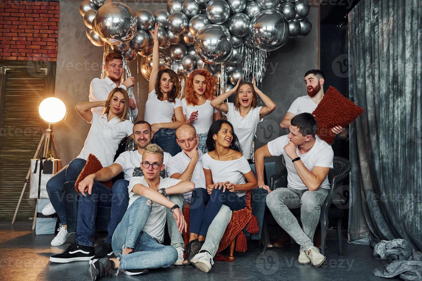 jóvenes felices celebrando el año nuevo en una habitación decorada con navidad con equipo de iluminación foto