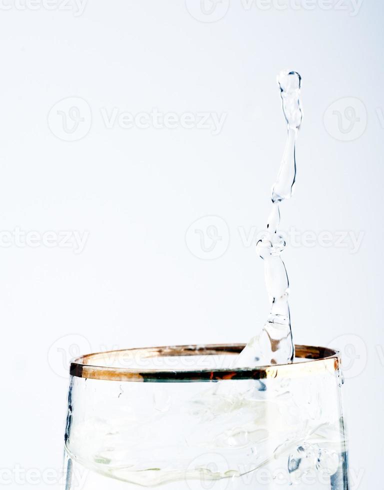 Lime splashing into glass of water photo