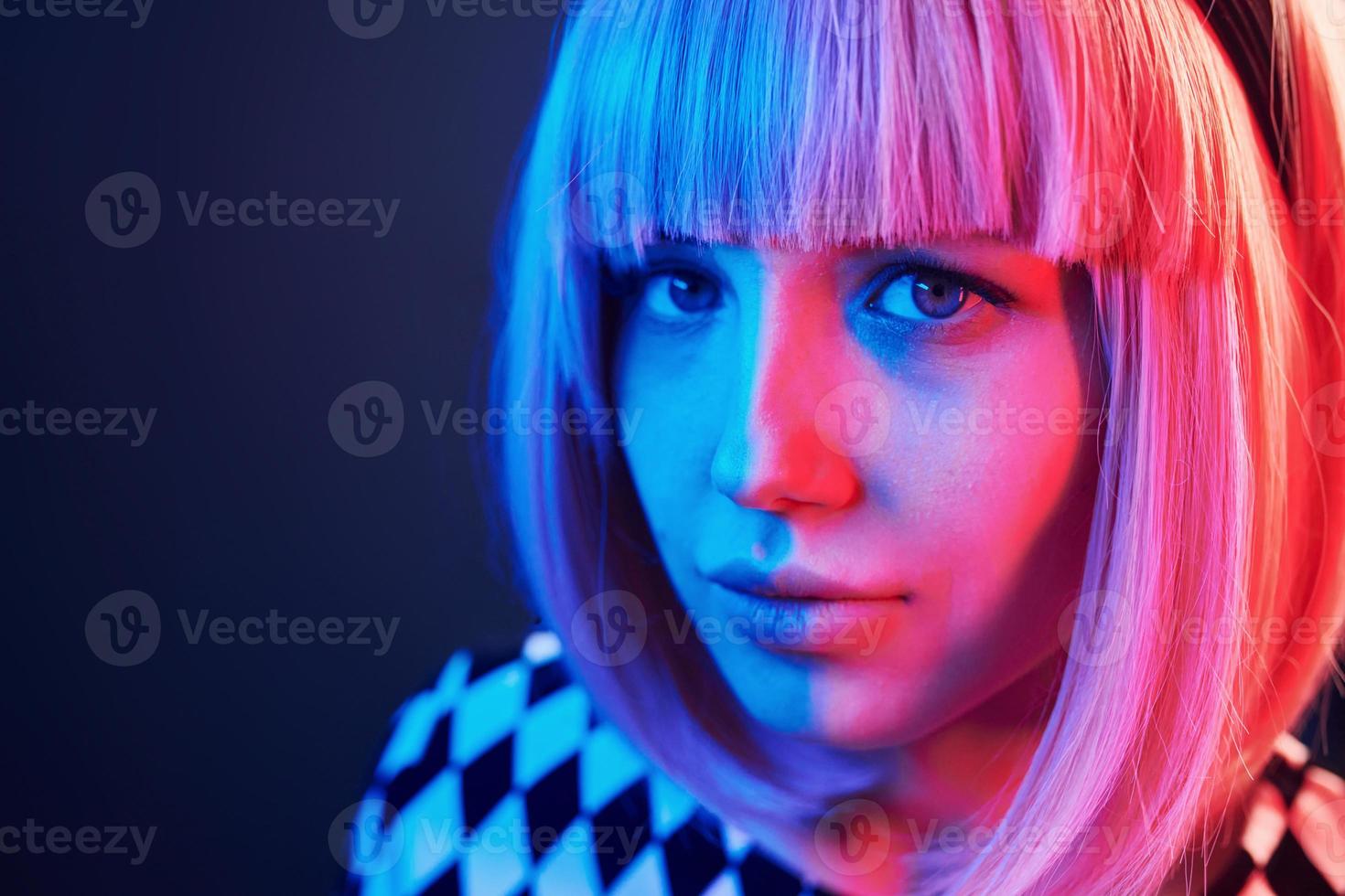 Portrait of young girl with blond hair in red and blue neon in studio photo