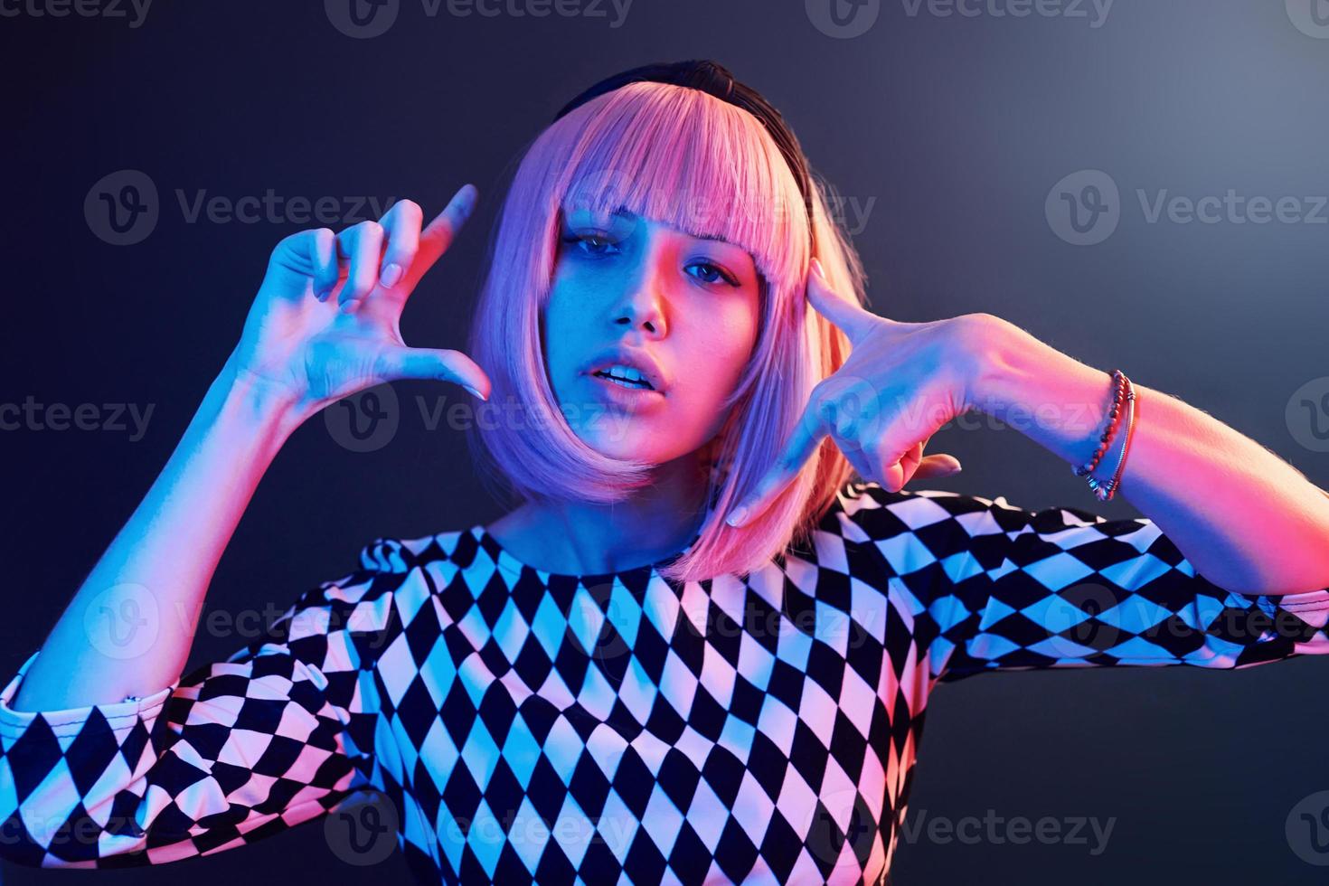 Portrait of young girl with blond hair in red and blue neon in studio photo