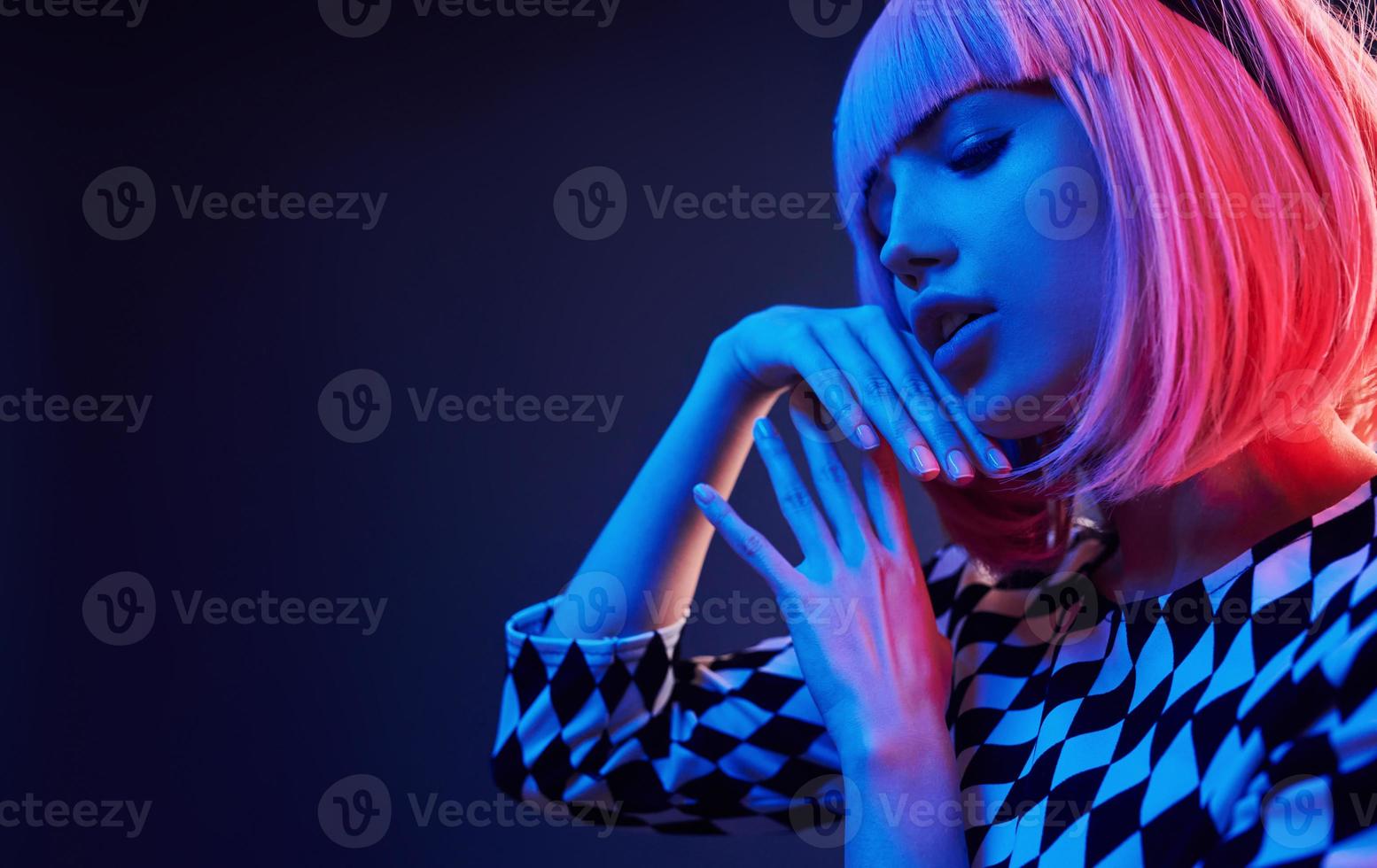 retrato de una joven con el pelo rubio en neón rojo y azul en el estudio foto