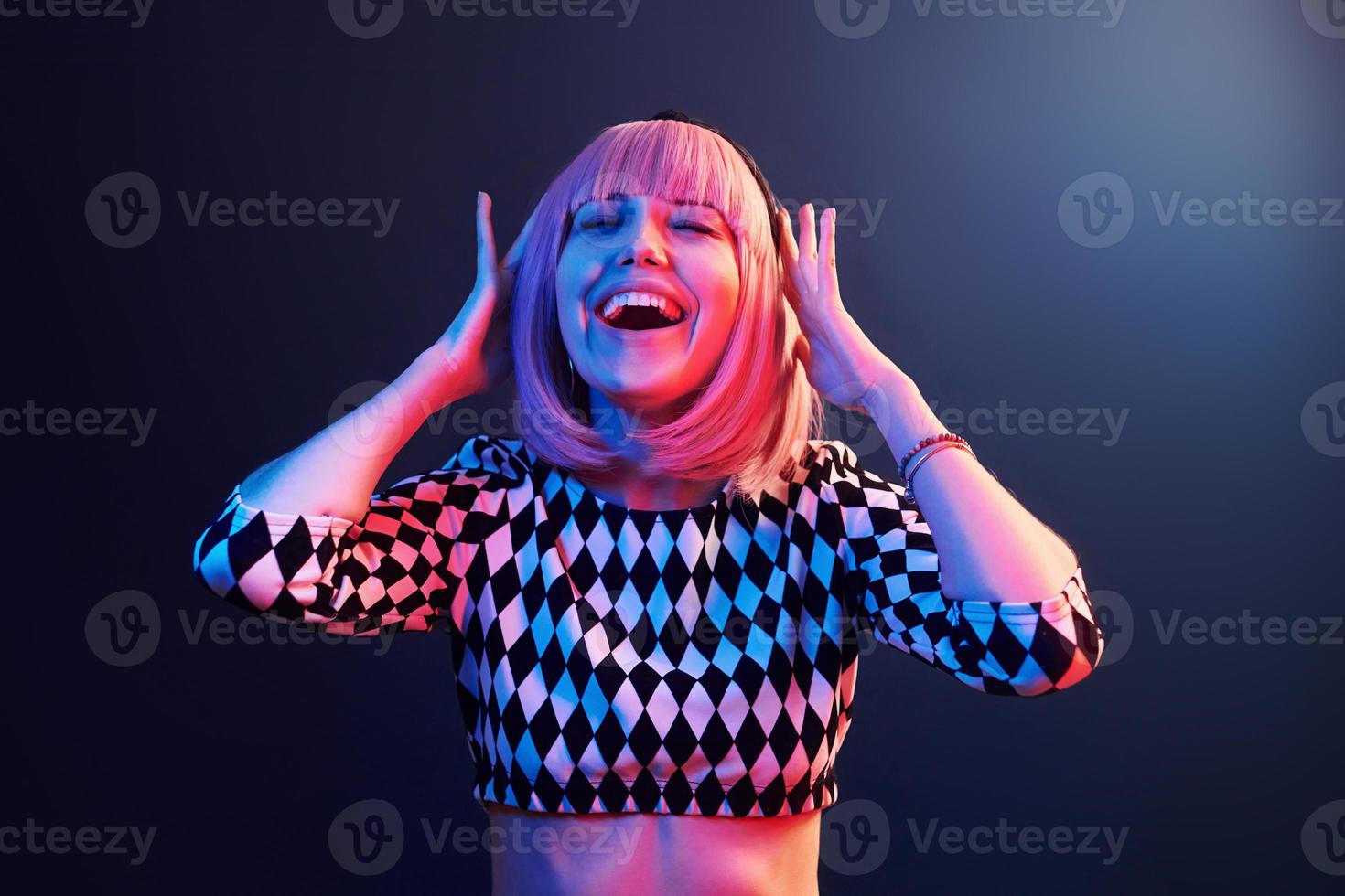 retrato de una joven con el pelo rubio en neón rojo y azul en el estudio foto