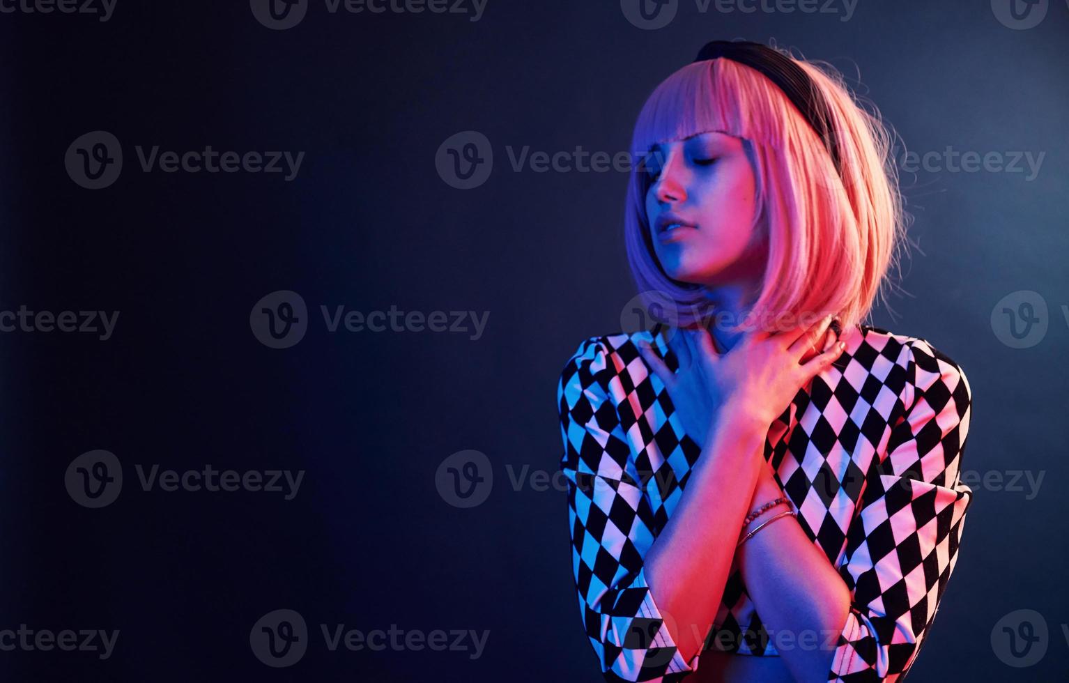 Portrait of young girl with blond hair in red and blue neon in studio photo