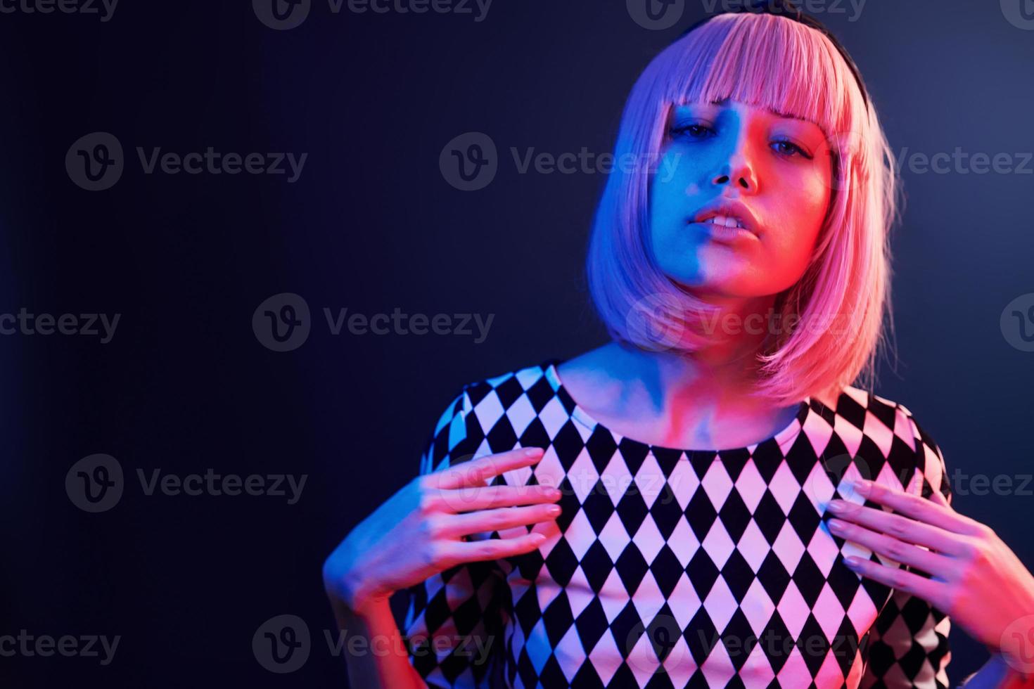 Portrait of young girl with blond hair in red and blue neon in studio photo