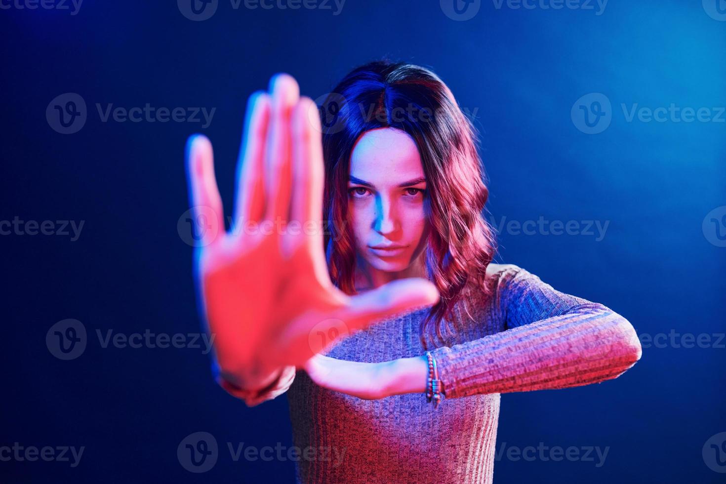 retrato de una joven con el pelo rizado en neón rojo y azul en el estudio foto