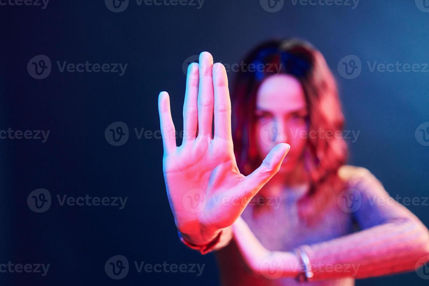 Portrait of young girl with curly hair in red and blue neon in studio photo