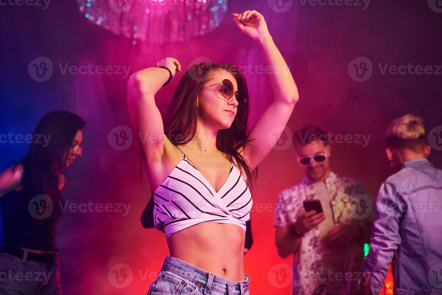 Young people is having fun in night club with colorful laser lights photo