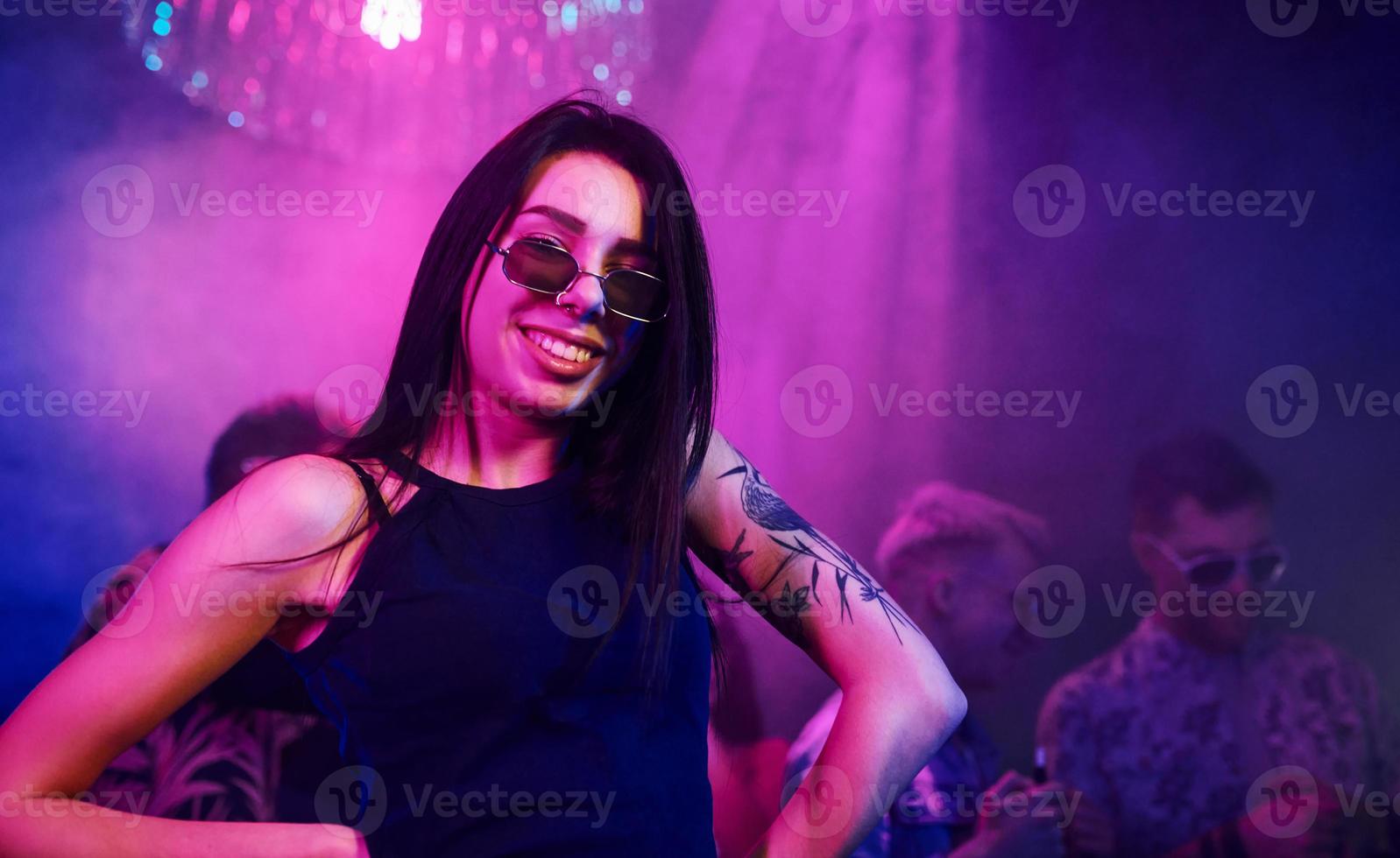 Young people is having fun in night club with colorful laser lights photo