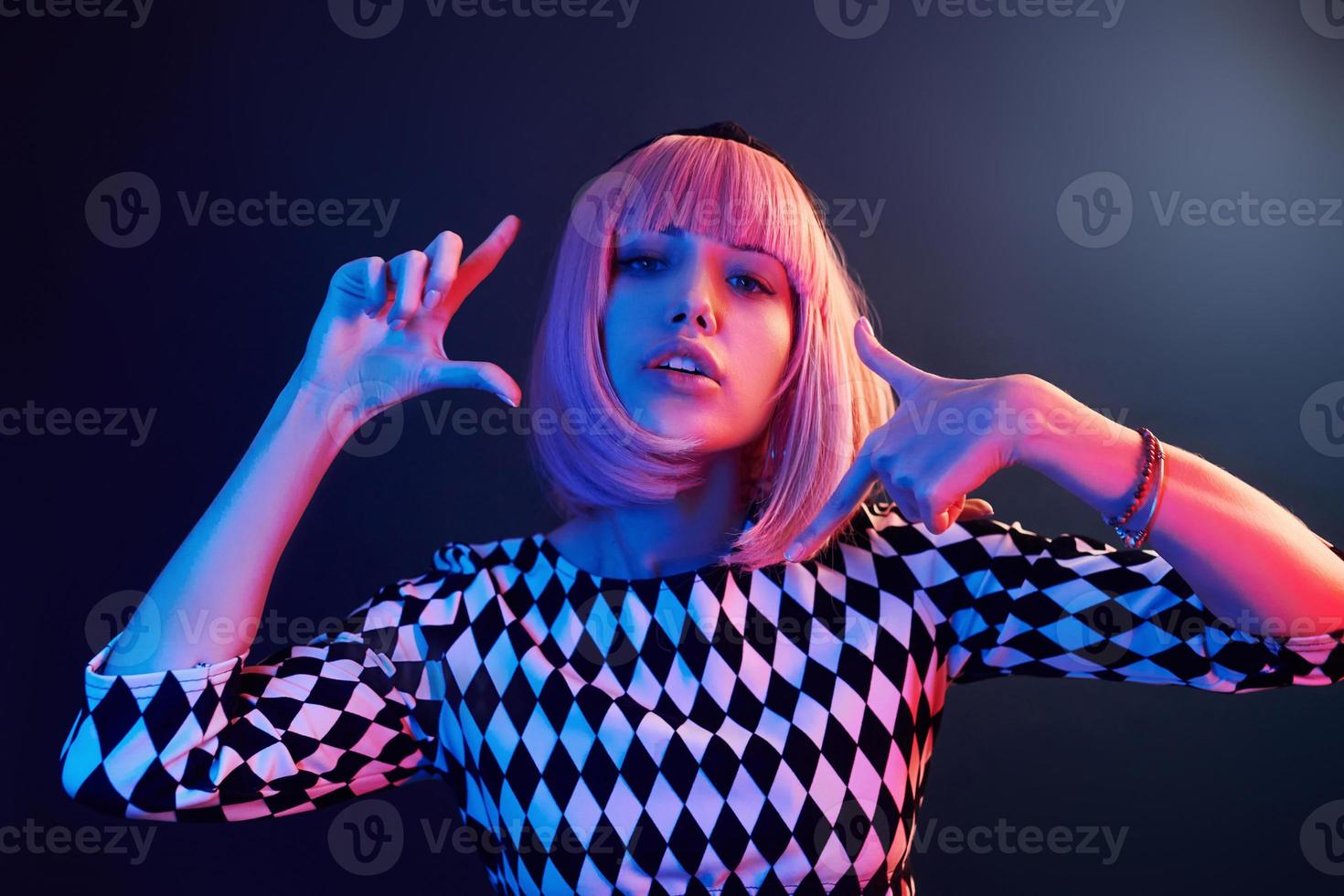 Portrait of young girl with blond hair in red and blue neon in studio photo