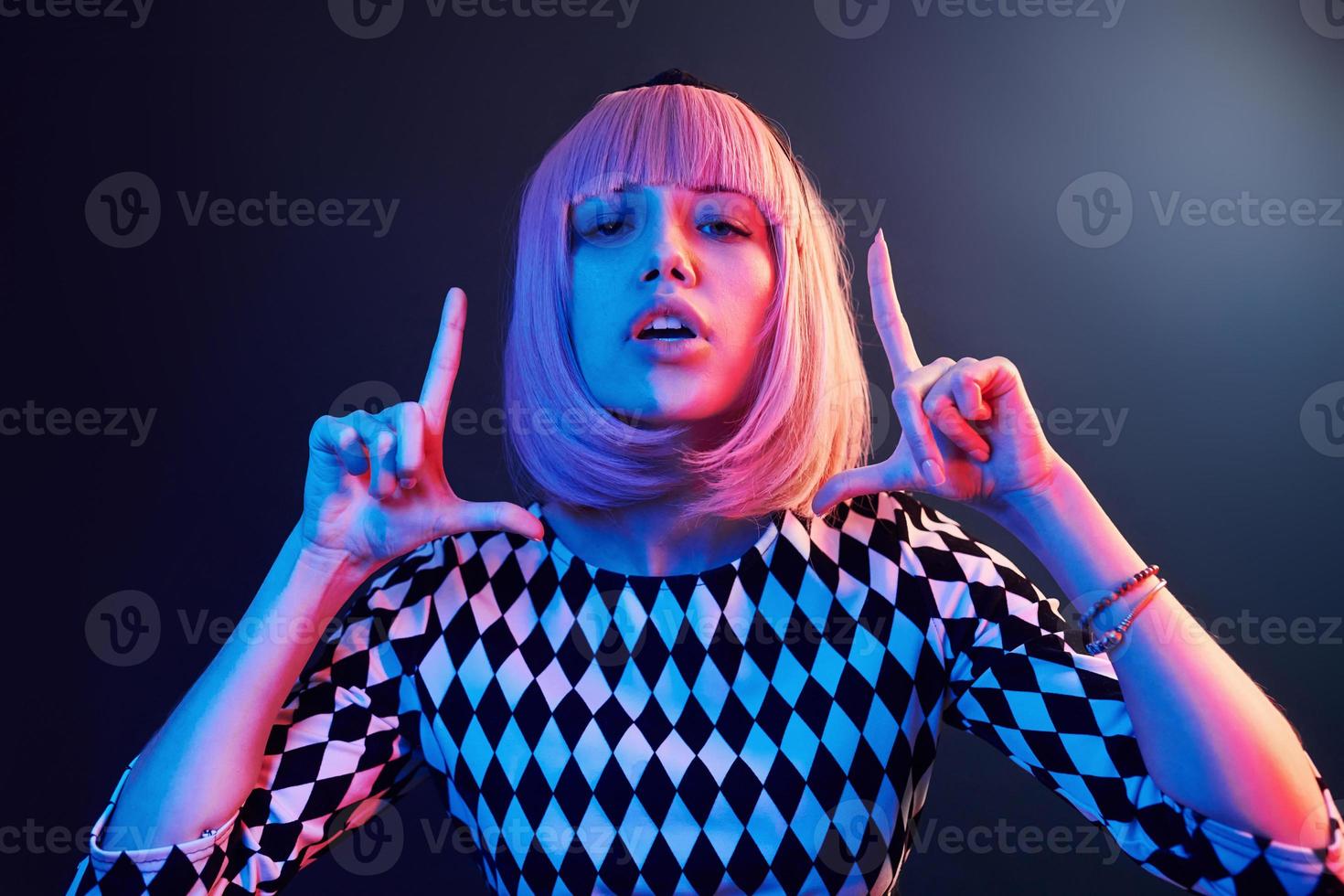 Portrait of young girl with blond hair in red and blue neon in studio photo