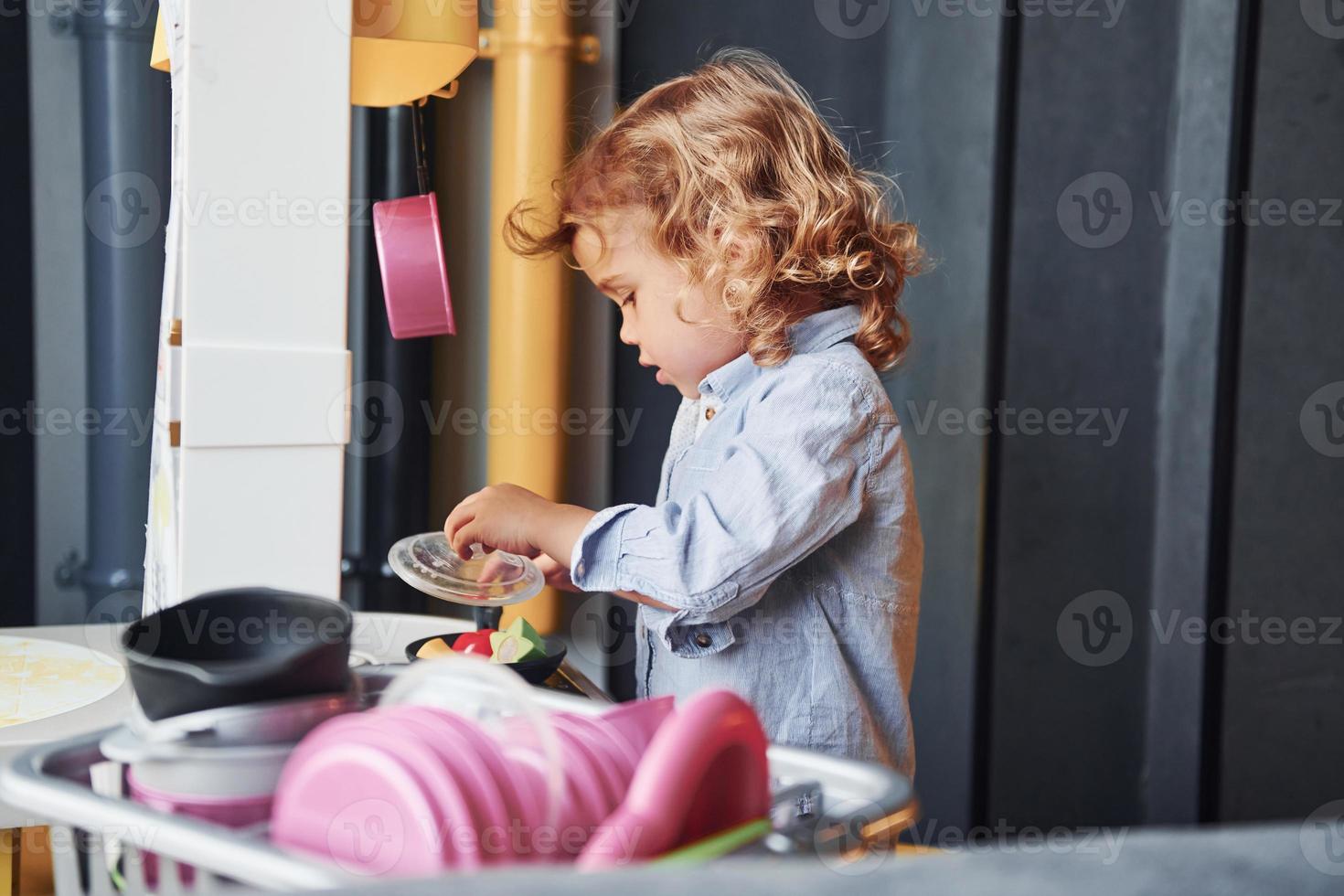 Child in casual clothes have fun by learning how to prepare food photo