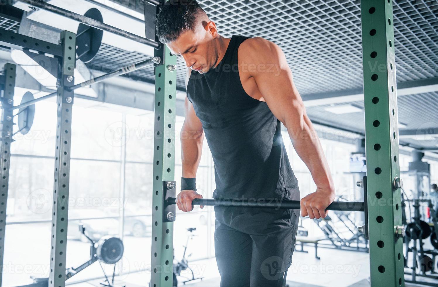 Strong young man in sportive clothes have fitness day in the gym photo